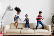 © Lisa Tichané - Trois enfants dansent sur le canapé du salon