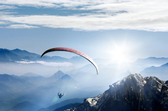 Fototapete - Paragliding im Hochgebirge bei Sonnenaufgang