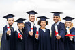 © Syda Productions - happy students in mortar boards with diplomas
