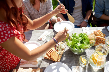 happy friends having dinner at summer party