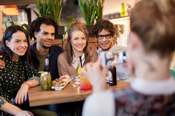 Canvas Print - friends with smartphone photographing at cafe