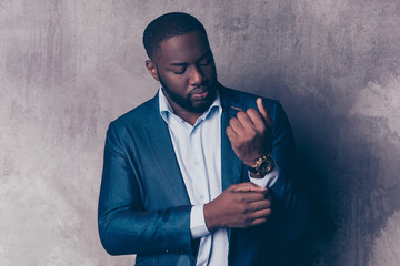 Close up portrait of handsome bearded afroamerican man in formalwear fasten cufflinks