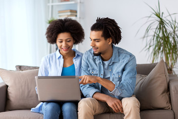 Wall Mural - smiling happy couple with laptop at home