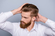 © deagreez - Portrait of confident man with red beard touching his hair