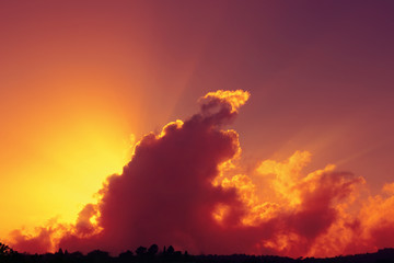 Wall Mural - Cielo rosso al tramonto con raggi di sole che spuntano dietro ad una nuvola