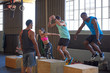 Dedicated people doing box jumps exercise fitness training