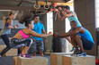 Trainer motivating class doing box jumps fitness boot camp training 