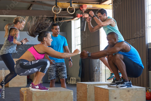 Fotografie, Obraz Trainer motivating class doing box jumps fitness boot camp training