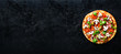 © jchizhe - Fresh italian pizza with mushrooms, ham, tomatoes, cheese, olive, basil on black concrete background. Copy space. Homemade with love. Fast delivery. Recipe and menu. Banner.