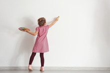 Cute Little Girl Painting On Wall In Empty Room