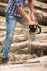 Wall Mural - Guy cuts wood with a chainsaw