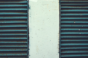 Two rusty old ventilation grille in the wall. Building facade with qld ragged plaster and metal ventilation grilles. Symmetry background