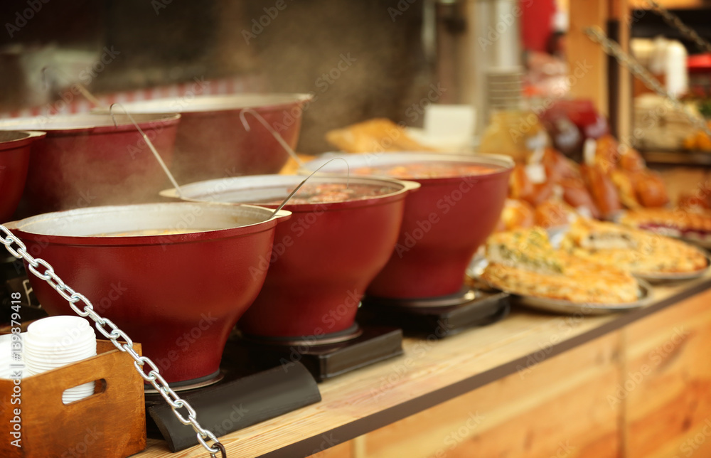 Cauldrons with mulled wine on counter at Christmas fair kiosk
