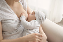 Young Woman Breastfeeding Her Little Baby At Home