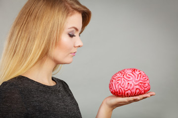 woman thinking and holding fake brain