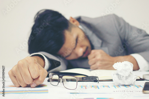 Businessman Sleeping At His Desk Working Over A Laptop On