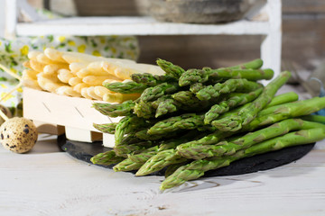 Spring season - fresh white and green asparagus on black stone plate