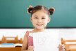 © Tom Wang - happy little girl showing exam paper with a plus in classroom