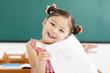 © Tom Wang - happy little girl showing exam paper with a plus in classroom