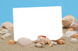 Weiße Blatt ohne Text ist auf Sand mit Muscheln. Sommer Grüßkarte oder leeres Template.