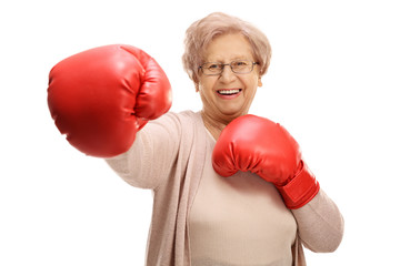 Poster - Joyful elderly woman with boxing gloves throwing a punch