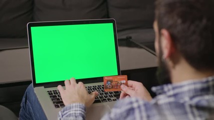 Poland, Lublin - 30 jan 2017: Close-up view of young man online shoping at home on pc, typing credit card number