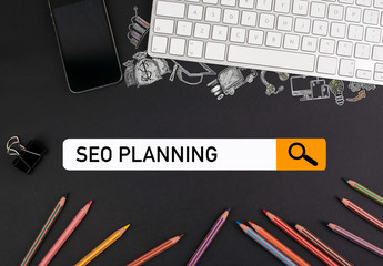 Wall Mural - SEO Search Engine Optimization concept. colorful pencils and a computer keyboard with a mobile phone on a black table.