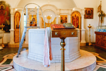 Wall Mural - Golden religious utensils - Bible, cross, prayer book, missal, baptismal font. Details in the Orthodox Christian Church. Russia.