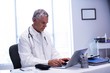 © WavebreakMediaMicro - Doctor sitting at table and using laptop