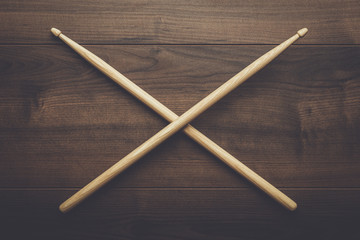 pair of wooden drumsticks crossed on wooden table