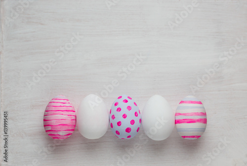 Plakat Wielkanocni jajka malowali w pastelowych kolorach na białym drewnianym tle