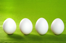White Eggs On A Green Fabric Texture Background