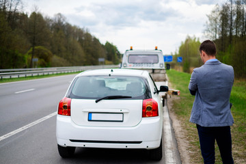 Wall Mural - Man calling while tow truck picking up his broken car