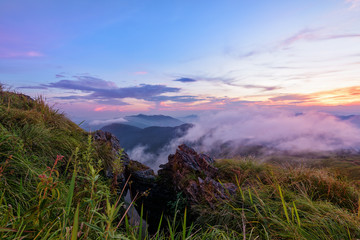 Beautiful landscape nature on peak mountain with sun cloud fog and bright colors of sky and sunlight during sunset in winter at viewpoint Phu Chi Fa Forest Park in Chiang Rai Province, Thailand