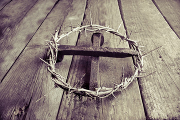 Crown of thorns with cross made of nails on wooden background