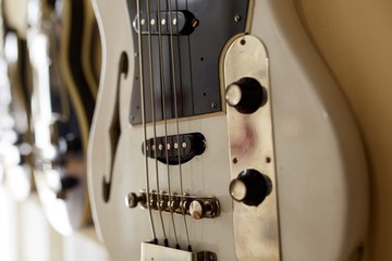  Old excellent electro and bass guitars on the shelf in the guitar shop