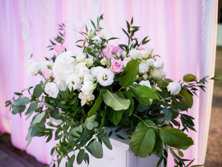 Wall Mural - Rich bouquet of roses and greenery stand on pillar before wedding altar