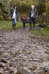 Wall Mural - Multi Generation Family Take Dog For Walk In Fall Landscape