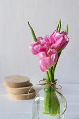 Wall Mural - Fresh pink tulip flowers bouquet in a glass jar on white background