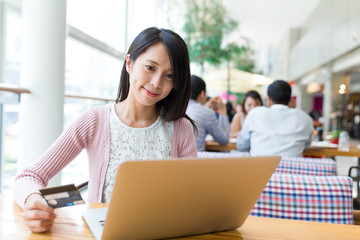 Poster - Woman use credit card to pay the bill on laptop computer