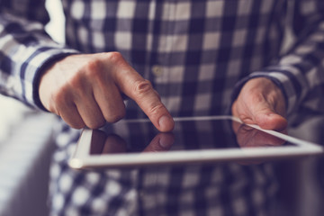 Wall Mural - man holding white digital tablet, toned