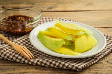 Wall Mural - Mango-with-sweet-fish-sauce on wood table.