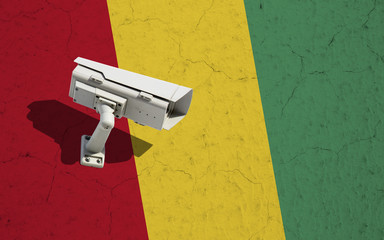 Security camera on textured wall with painted Guinea flag