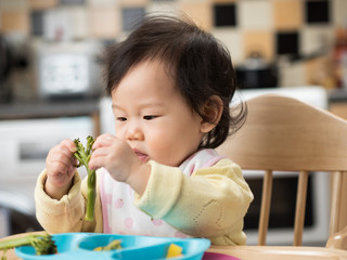 Wall Mural - baby eating vegetable at home