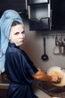 © Parilov - The girl washes the dirty dishes with a frying pan in a nourishing mask on the skin. Mask for rejuvenating and eliminating skin defects. Acne