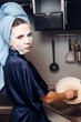 © Parilov - The girl washes the dirty dishes with a frying pan in a nourishing mask on the skin. Mask for rejuvenating and eliminating skin defects. Acne