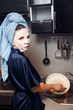 © Parilov - The girl washes the dirty dishes with a frying pan in a nourishing mask on the skin. Mask for rejuvenating and eliminating skin defects. Acne