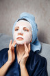 © Parilov - The girl applies and corrects the nourishing mask on the skin. Mask for rejuvenating and eliminating skin defects. Acne, acne.