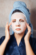 © Parilov - The girl applies and corrects the nourishing mask on the skin. Mask for rejuvenating and eliminating skin defects. Acne, acne.