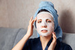 © Parilov - The girl applies and corrects the nourishing mask on the skin. Mask for rejuvenating and eliminating skin defects. Acne, acne.